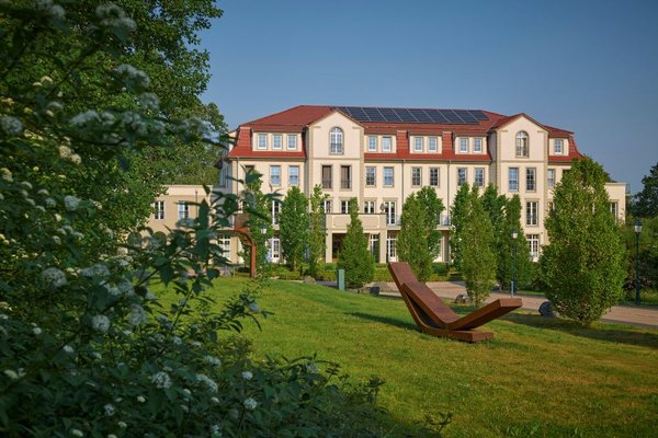 das Wellnesshotel Naturresort & Spa Schindelbruch von außen im Sommer in grüner Natur eingebettet.